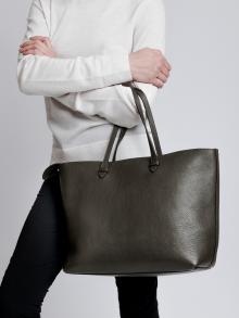 Female model in white sweater and black pants wearing bag from Lotuff