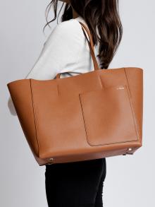Female model in white sweater and black pants wearing bag from Valextra