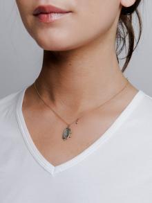 Female model wearing small pendant necklace by Rebecca Lankford