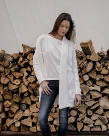 Model standing in front of wood burning logs wearing Ma Ry Ya Tee Ma Ry Ya Cardigan R13 Jean