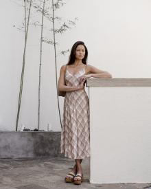 Female model posing against ledge wearing a Vince Dress K and Jacques Sandal