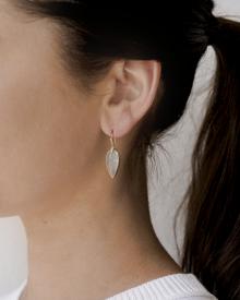 Close up of female ear wearing white sweater and forced jewelry on Annette Ferdinandsen