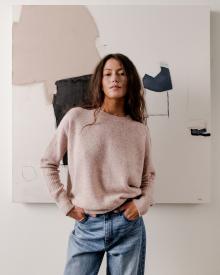 Model standing in front of painting wearing off white Brochu Walker Sweaterand blue L'agence Jean