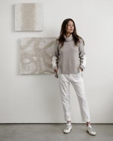 model wearing Brochu Walker sweater standing in front of paintings