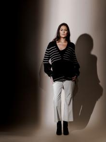 Model wearing black and white striped cardigan and white pants