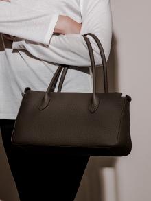 Model wearing brown leather purse 