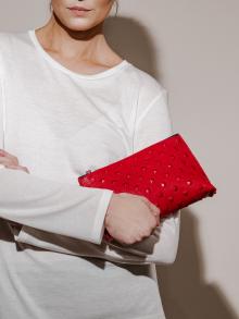 Model holding red leather clutch