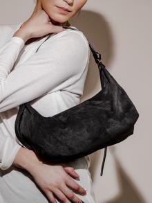 Model wearing black textured shoulder purse