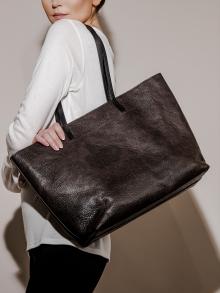 Model wearing brown large leather purse