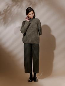 Model wearing gray sweater, black jeans and black boots