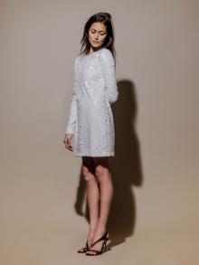 Model wearing white sequin long sleeve dress